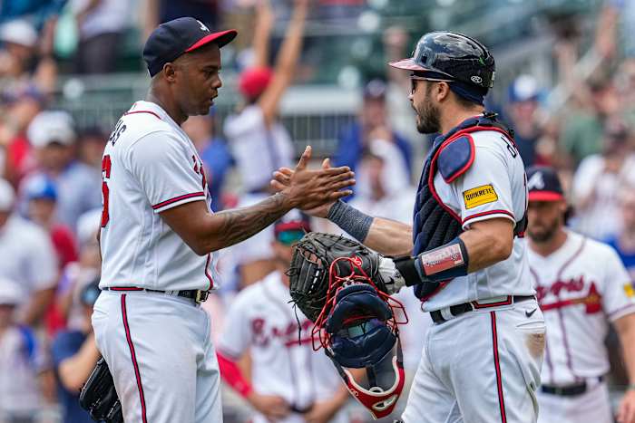 Jul 20, 2023; Cumberland, Georgia, USA; Atlanta Braves relief pitcher Raisel Iglesias (26) reacts with catcher Travis d'Arnaud (16) after the Braves defeated the Arizona Diamondbacks at Truist Park.